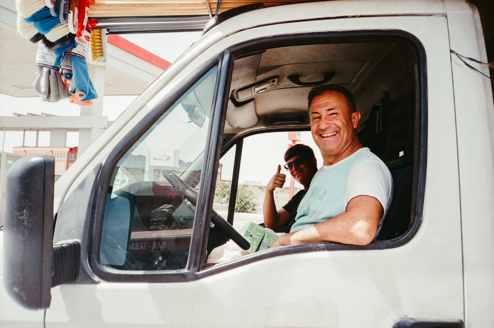 Motorista sorrindo na cabine da van de entrega
